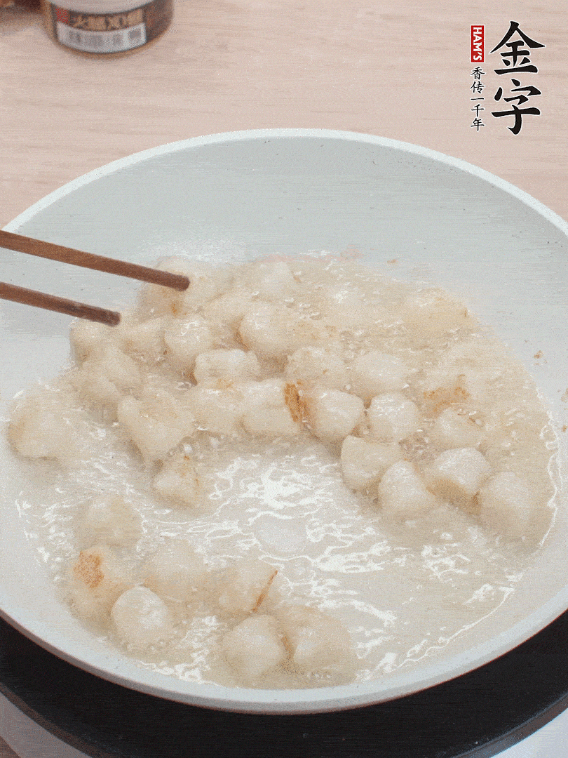 油溫4成熱，鮮貝蘸干淀粉下鍋煎，一面微黃后翻面。
