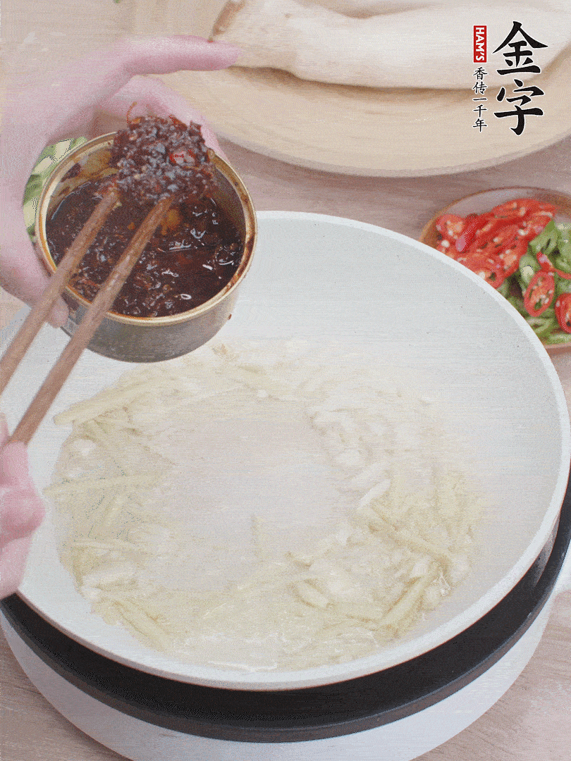 起鍋熱油，姜蒜、金字火腿干貝醬煸香。