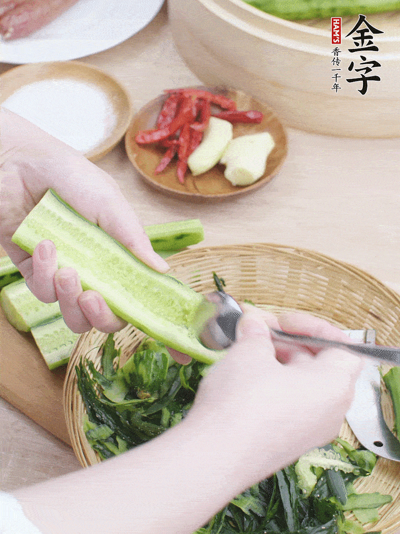 黃瓜削皮，對(duì)半切開，勺子挖去內(nèi)瓤，斜刀切片。青蒜斜刀切段。